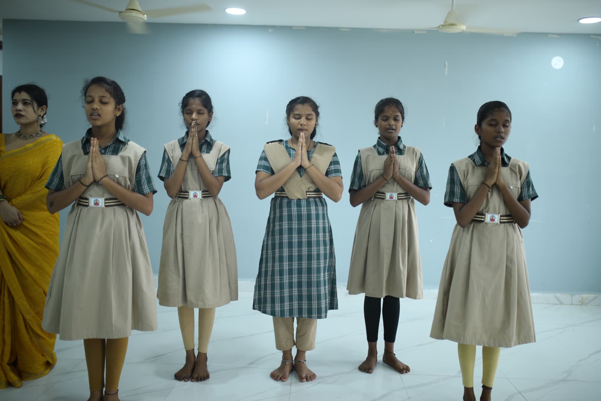 Aadarana schoolgirls standing together in prayer