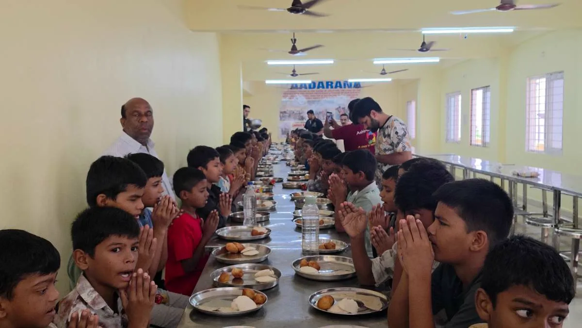 Children saying grace before a sponsored meal in the dining hall