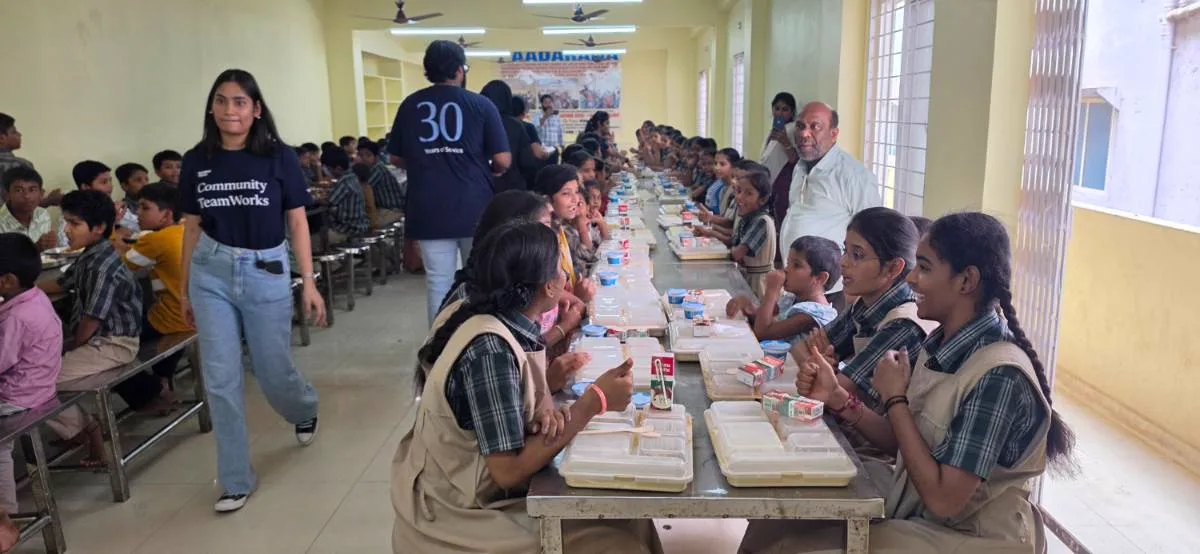 A corporate volunteer team serving lunch in the dining hall